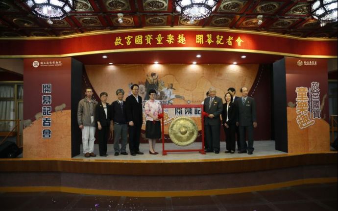 故宮國寶童樂趣開幕記者會 開幕敲鑼儀式：由右至左依序為：奉天宮郭碧東監事主席、教育展資處謝俊科副處長、信義區游竹萍區長、奉天宮陳博貞主任委員、黃盒子互動工程張啟明總監、國立故宮博物院馮明珠院長、民政局吳坤宏副局長、教育展資處林國平處長、臺北翡翠水庫管理局余星華主任秘書、國立政治大學蔡瑞煌教授